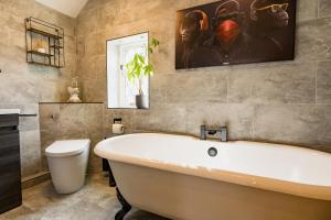 baño con bañera blanca y una pintura en la pared en Spacious & well decorated 4 bedroom home near Chester en Saughall