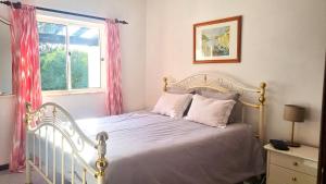 a bedroom with a white bed and a window at Casa Flora - Vale da Telha - Nature - Surf & Sun in Aljezur