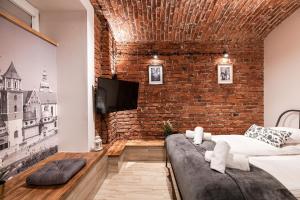 salon z ceglaną ścianą i kanapą w obiekcie DIETLA 99 APARTMENTS - IDEAL LOCATION - in the heart of Krakow w Krakowie