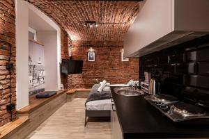 a kitchen with a sink and a brick wall at DIETLA 99 APARTMENTS - IDEAL LOCATION - in the heart of Krakow in Kraków