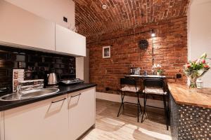 a kitchen with a counter and a brick wall at DIETLA 99 APARTMENTS - IDEAL LOCATION - in the heart of Krakow in Kraków