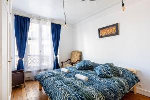 a bedroom with a bed with a blue comforter at GuestReady - Luxury Living near Panthéon in Paris