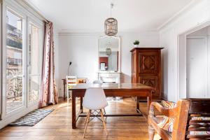 a dining room with a wooden table and a chair at GuestReady - Luxury Living near Panthéon in Paris