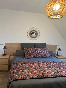 a bedroom with a bed with a floral bedspread at ARC EN CIEL B&B in Pontorson