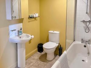 een badkamer met een toilet, een wastafel en een bad bij Black Buoy Inn in Wivenhoe