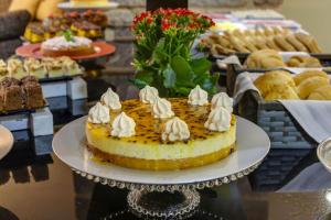 a cake on a plate on a table with other desserts at Flat Pietra in Florianópolis