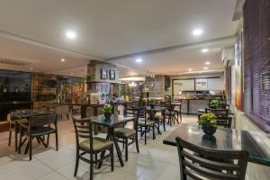 a dining room with tables and chairs in a restaurant at Flat Pietra in Florianópolis