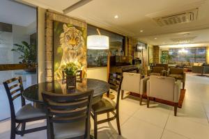 a dining room with a table and a painting of a tiger at Flat Pietra in Florianópolis