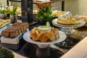 a buffet filled with different types of cakes and pies at Flat Pietra in Florianópolis