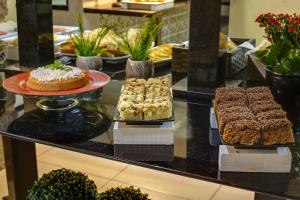 a buffet with cakes and other desserts on a counter at Flat Pietra in Florianópolis