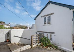 a white house with a window and a fence at Pearl Cottage - St Agnes in St. Agnes