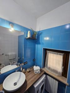 a bathroom with a white sink and a blue wall at Colazione da Tiffany in Bussolengo +18 photos