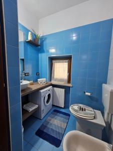 a blue bathroom with a washing machine in it at Colazione da Tiffany in Bussolengo