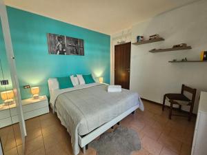 a bedroom with a bed and a blue wall at Colazione da Tiffany in Bussolengo