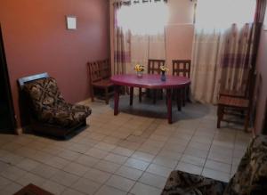 コチャバンバにあるLa Casa Discreta Cochabambaの紫色のテーブルと椅子、窓が備わる客室です。