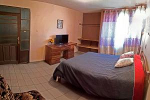 a bedroom with a bed and a tv and a window at La Casa Discreta Cochabamba in Cochabamba