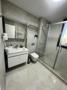 La salle de bains est pourvue d'une douche, d'un lavabo et de toilettes. dans l'établissement Apartments in Solid House Mamaia, à Mamaia