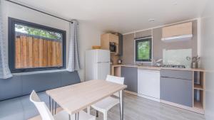 a kitchen and dining room with a table and chairs at Camping Etennemare in Saint-Valery-en-Caux