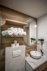 y baño con lavabo, espejo y toallas. en M3 en Kraljevo