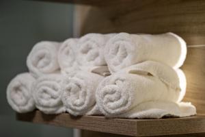 una pila de toallas blancas en una estantería de madera en M3 en Kraljevo