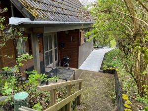Un porche de una casa con una valla y una acera. en Ferienhaus 39 Kratzmühle Altmühlthal, en Kinding