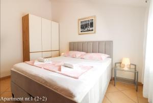 a bedroom with a bed with pink towels on it at Apartments Jurić in Vrsar