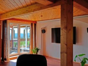 una sala de estar con techos de madera y una gran ventana. en Holiday home Scharzwald, en Hinterfalkau