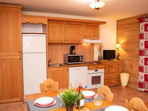 a kitchen with a table and a white refrigerator at Appartement Uvernet-Fours, 3 pièces, 8 personnes - FR-1-504-7 in Uvernet