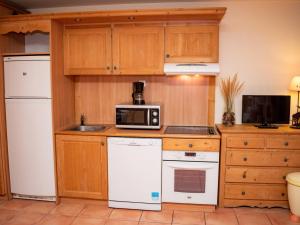 a kitchen with white appliances and wooden cabinets at Appartement Uvernet-Fours, 3 pièces, 8 personnes - FR-1-504-7 in Uvernet
