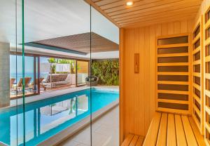 a swimming pool in a house with a glass wall at Dubrovnik luxury apartments in Dubrovnik