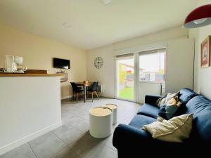 un salon avec un canapé bleu et une table dans l'établissement Charmant T1 bis à Cambo-les-Bains avec terrasse, proche des thermes, pour 2 personnes - FR-1-495-94, à Cambo-les-Bains