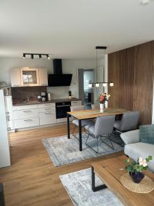 a living room with a table and a kitchen at Ostseemöwe NEU in Zingst