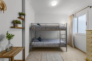 a bedroom with two bunk beds and a table at Famara Power Apartment in Famara