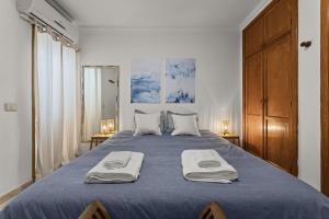 a bedroom with a blue bed with two towels on it at Famara Power Apartment in Famara