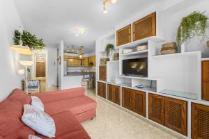 un soggiorno con divano rosso e TV di Famara Power Apartment a Famara