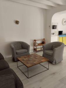 sala de estar con 2 sillas y mesa de centro en la JoLie ruche en Saint-Georges-sur-Cher