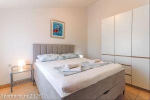 a bedroom with a large bed with a cabinet at Apartments Jurić in Vrsar