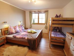 ein Schlafzimmer mit einem Bett und einem Etagenbett in der Unterkunft Cosy holiday flat in a farmhouse in Taxenbach