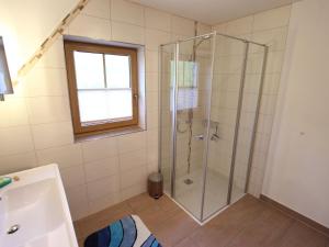 ein Bad mit einer Dusche und einer Glastür in der Unterkunft Cosy holiday flat in a farmhouse in Taxenbach