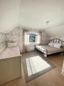 1 dormitorio con 2 camas y ventana en Bestemors hus - med kystnær beliggenhet, en Fredrikstad