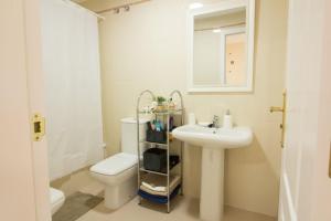 a bathroom with a sink and a toilet and a mirror at Barlovento in Algarrobo