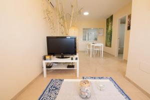 een woonkamer met een flatscreen-tv op een tafel bij Barlovento in Algarrobo