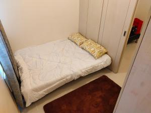 マニラにあるStaycation in Quezon Cityの枕付きの部屋の小さなベッド1台