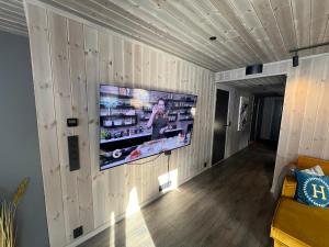 ein Wohnzimmer mit einem TV an einer Holzwand in der Unterkunft Fjellandsbyen 307 in Hemsedal