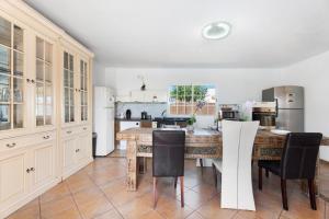 a kitchen with a large wooden table and black chairs at Villa Golf del Sur in San Miguel de Abona