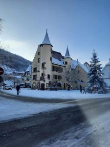 a large building with a christmas tree in the snow at LE CHANT DE LA RIVIERE in Sainte-Marie-aux-Mines
