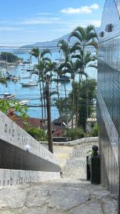 vistas a un puerto con palmeras y barcos en Mansão Espetacular Angra, en Angra dos Reis