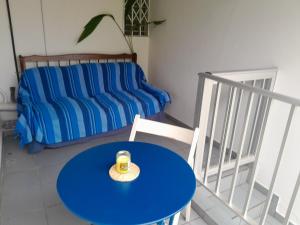 Una mesa y sillas azules en una habitación con un sofá. en L'îlet cacao, en Le Gosier