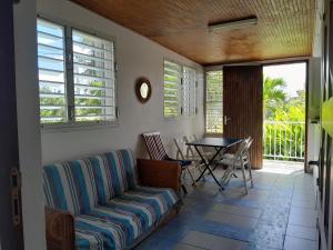 una sala de estar con un sofá y una mesa en L'îlet cacao, en Le Gosier