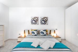 een witte slaapkamer met een groot bed met kussens bij Aaron Beautifull House in Arona +25 foto's